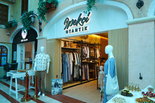 Storefront of 'IPEKCI OTANTIK' with mannequins and clothing displayed outside.